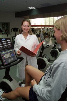 dietitian counseling student on exercise equipment