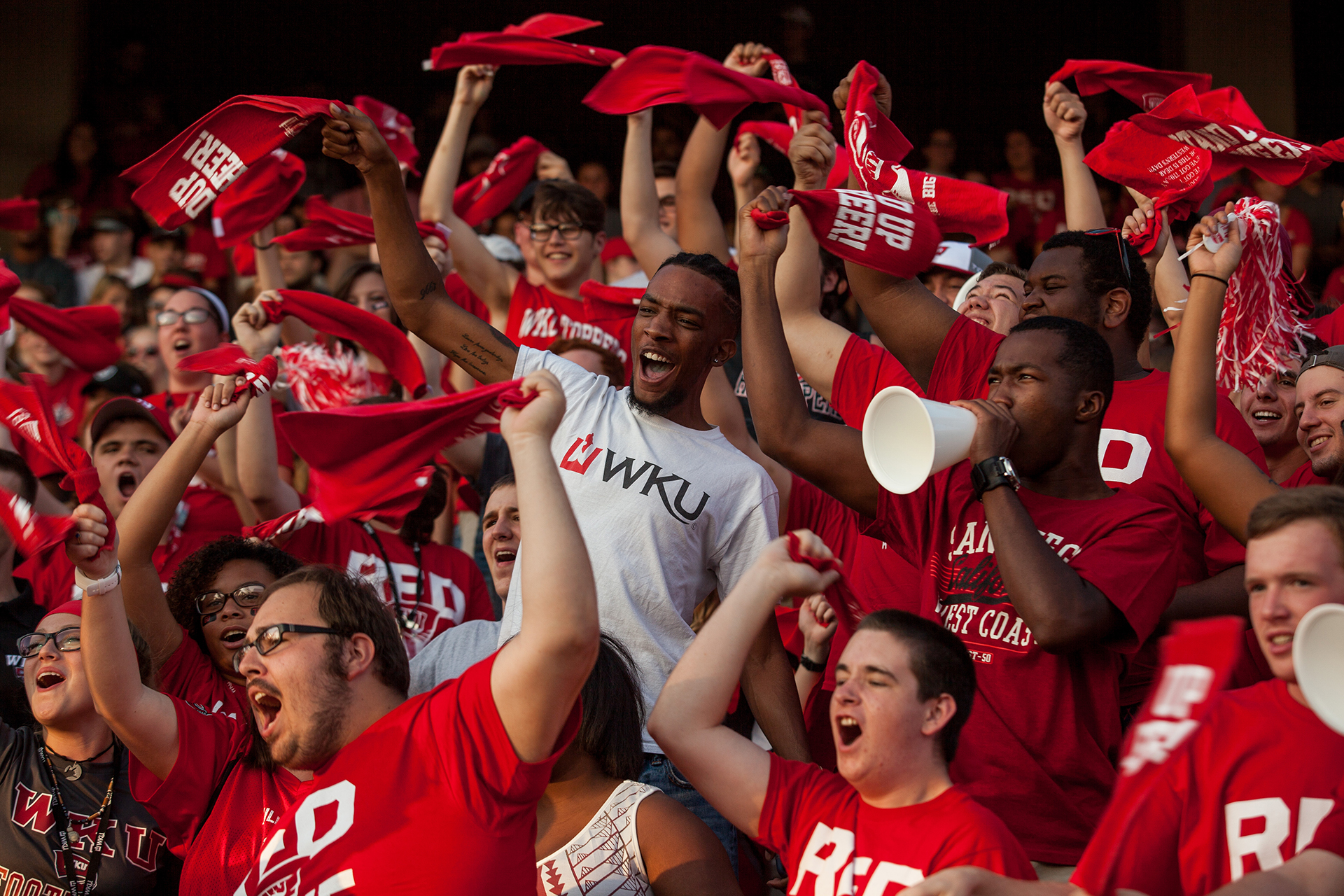 Students at a pep rally waving red WKU towels