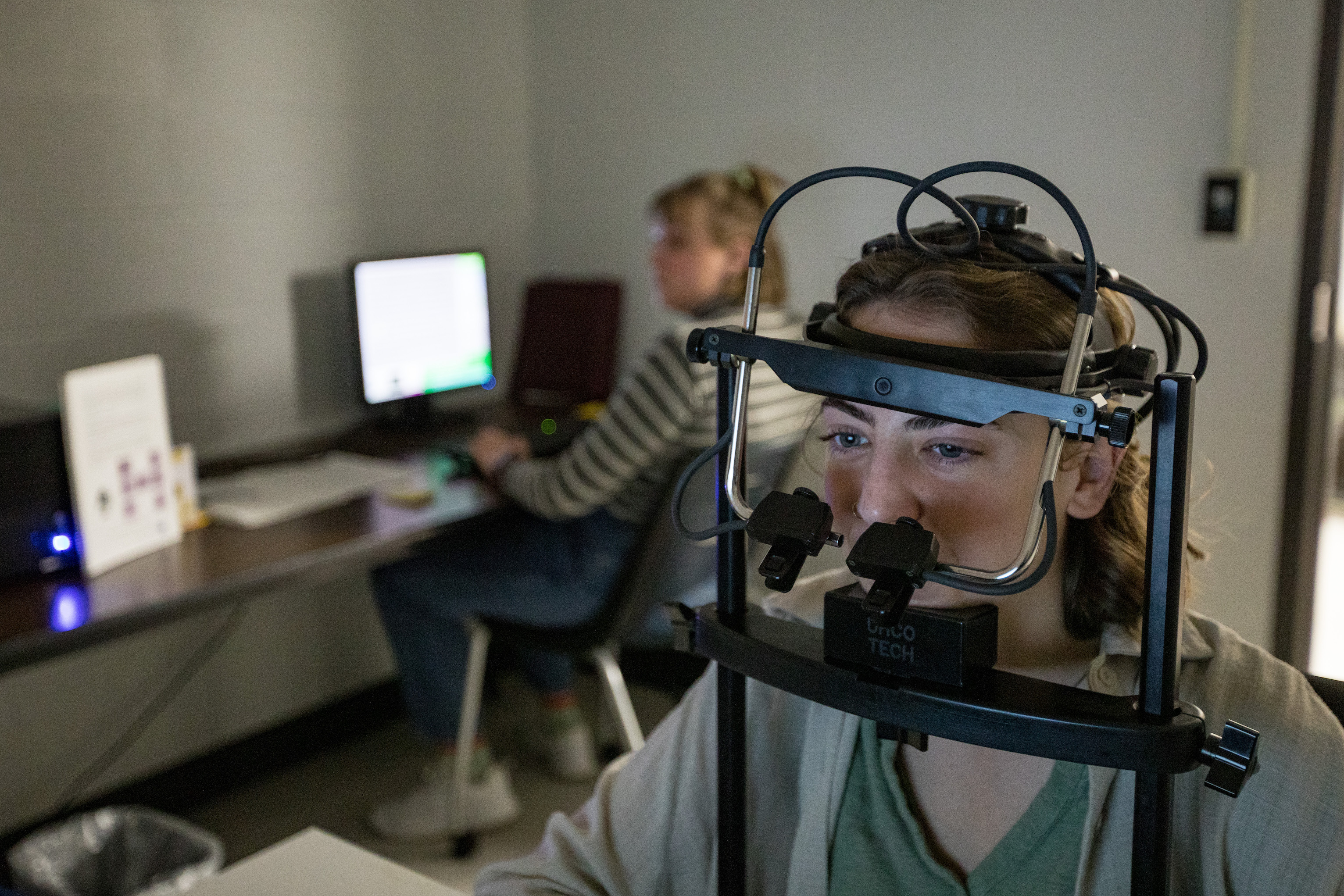 A student's head rests in an eye tracking device.