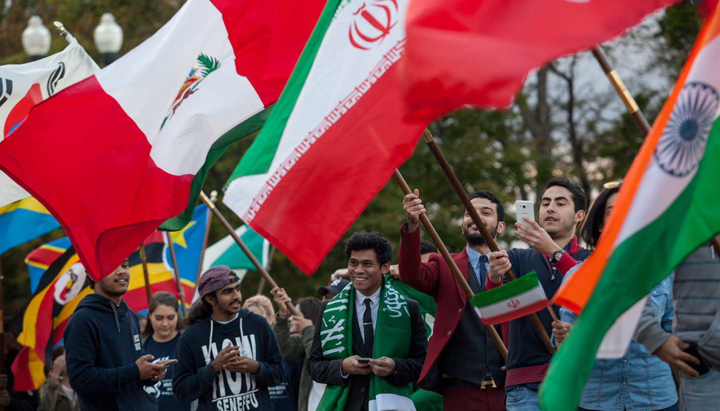 international students carrying flags at homecoming